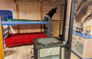 Stockbetten und Kaminofen im Innenraum
