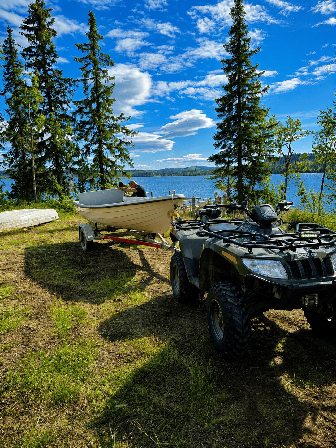 Boot, Quad und Seeufer an einem Sommertag in Schwedisch-Lappland